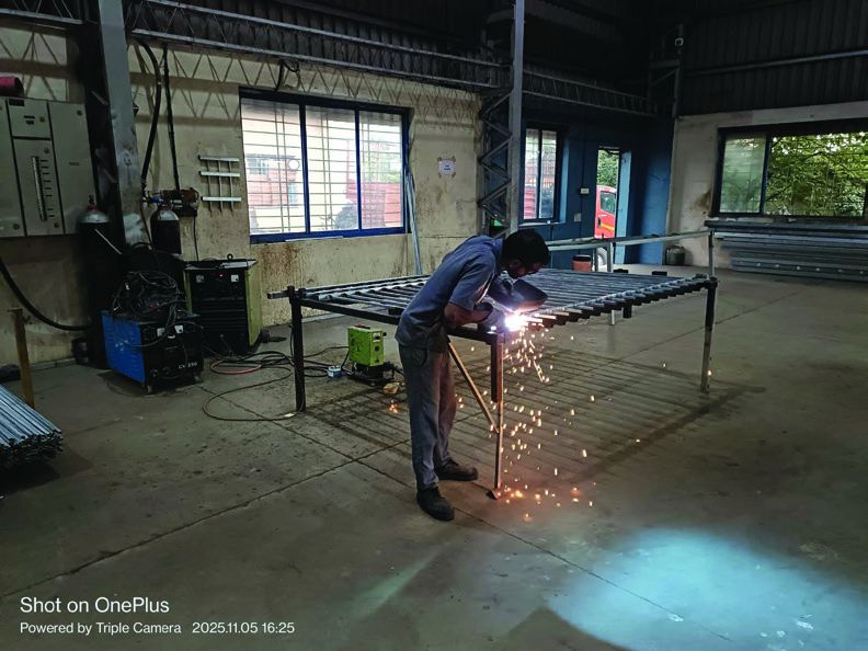 Craftsperson welding a steel fence panel